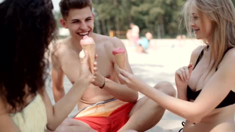 Young-people-enjoying-a-day-at-the-lake-and-eating-ice-creams.
