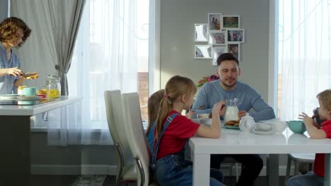 Familia-de-cinco-desayunando-en-casa