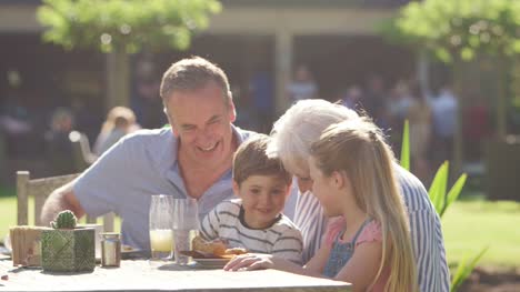 Grandparents-With-Grandchildren-Enjoying-Outdoor-Summer-Pub-Lunch