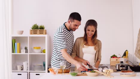 glückliches-Paar-Garen-von-Speisen-in-der-Küche-zu-Hause