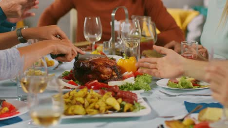 Close-up-Camera-Shot:-Big-Family-and-Friends-Celebration-at-Home,-Diverse-Group-of-Young-and-Old-People-Share-Meals,-Carve-Turkey,-Pass-Dishes,-Eat-Food-and-Drink.