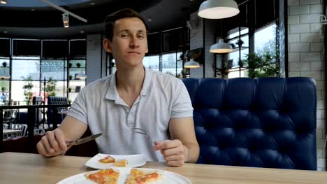 Pizza-de-hombre-guapo-joven-comiendo-en-un-café