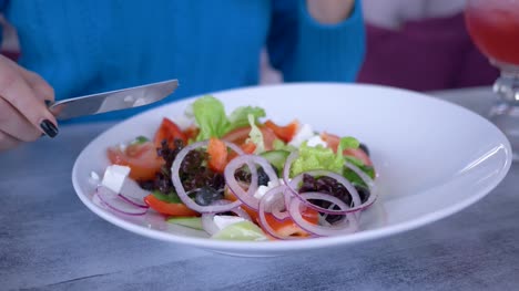 schöne-gesunde-Ernährung-ganz-nah,-griechischer-Gemüsesalat-aus-großen-Teller-isst-der-Mensch-nützlich-Abendessens-auf-Diät