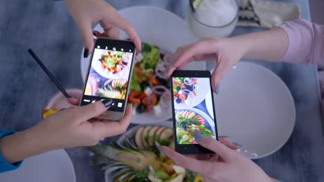 Blogging,-macht-Smartphone-in-Hand-Freundinnen-Foto-von-nützlichen-vegetarische-Essen-während-des-Frühstücks-für-social-Media,-Nahaufnahme