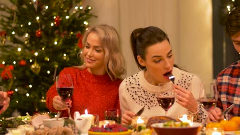 happy-friends-having-home-christmas-dinner-party