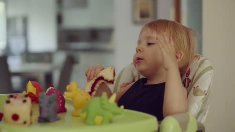 kleiner-Junge-sitzt-auf-Hochstuhl-Sandwich-zu-essen