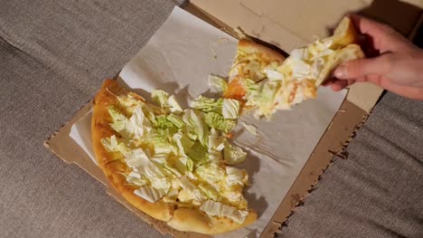 Jóvenes-que-rebanadas-de-pizza-deliciosa-de-caja-de-cartón