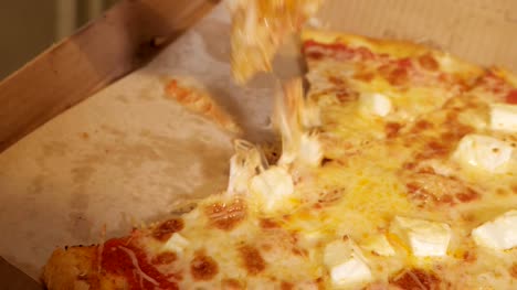 Stück-Pizza-in-der-hand