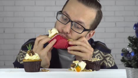 Brunette-man-eats-cupcakes-with-greed
