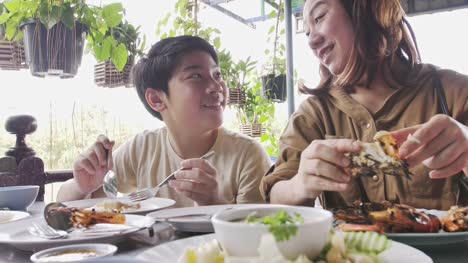 Lenta-de-la-feliz-madre-de-familia-asiática-e-hijo-comer