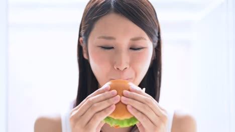 young-woman-eating-hamburger