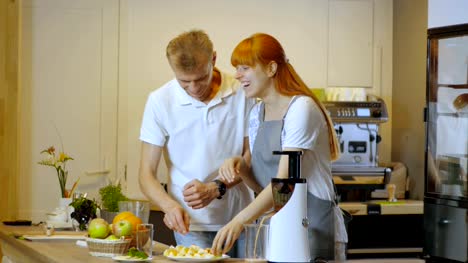 Glückliches-Paar-machen-gesunde-Bio-Säfte-in-Küche