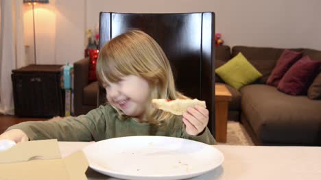 kleines-Kind-Pizza-Essen-und-Lachen-zu-Hause