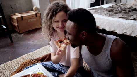 Frau-bietet-Pizza-Mann,-aber-Scheibe-alleine-essen.-Gemischtrassige-paar-Spaß-während-des-Essens-mit-Fast-food