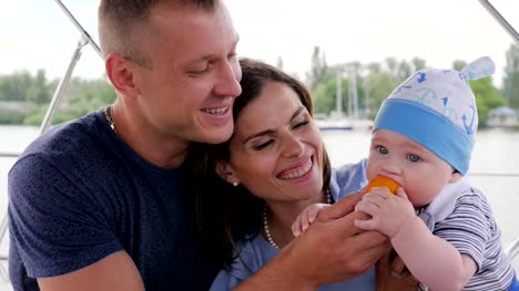 love-couple-together-with-small-kid,-caring-for-baby-during-summer-holidays,-happy-family-rest-on-river,-parents-with-child
