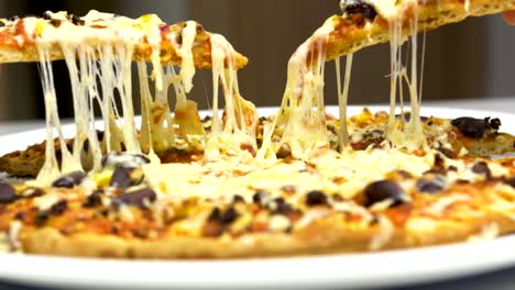 Zwei-Hände-nehmen-heiße-Pizza-mit-Käse-überbacken