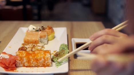 Freunde-Essen-Sushi-und-Dip-in-Soße-in-der-Sushi-bar