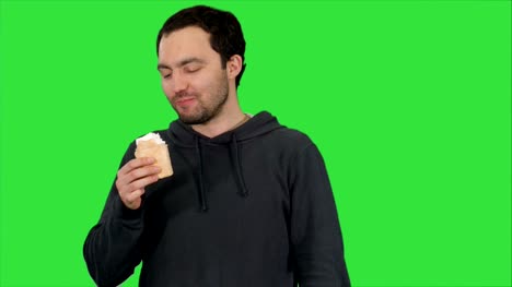 Handsome-young-man-eating-ice-cream-on-a-Green-Screen,-Chroma-Key