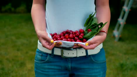 Woman-holds-a-cherries-inside-T-shirt