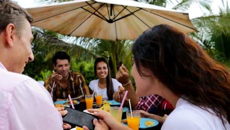 Leute-sitzen-am-Tisch,-Essen-im-Freien-auf-der-Terrasse-Gruppe-junger-Freunde-glücklich-lächelnd-Closeup-Kommunikation-reden