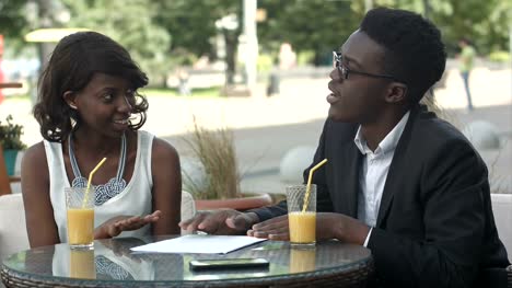 Gente-de-negocios-afroamericano-con-papeles,-explicando-detalles-teniendo-una-reunión-en-un-café