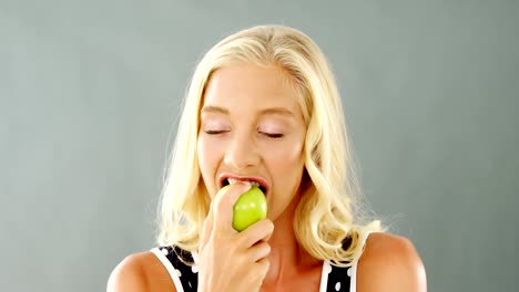 Retrato-de-hermosa-mujer-de-comer-manzana-verde
