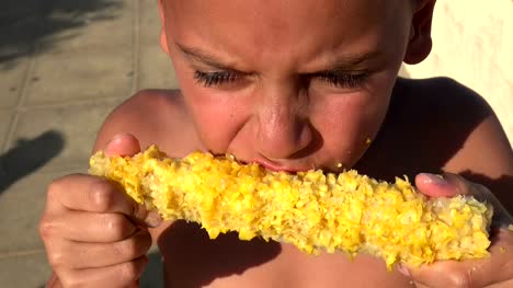 Hungry-refugee-boy-eating-corn-on-the-cob