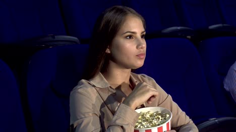 Das-Mädchen-zeigt-ein-Zeichen-der-Stille-im-Kinosaal-sitzen