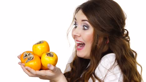 Cheerful-woman-holds-persimmon-kaki-fruits,-isolated