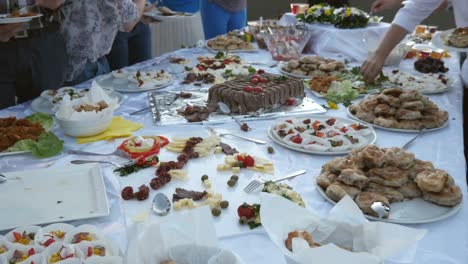 Aufnahmen-von-mehrere-Menschen,-die-Essen-auf-ihrem-Teller-von-einem-schwedischen-Tisch