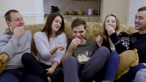 Junge-Menschen-isst-Popcorn-und-Film-zu-Hause-Uhren