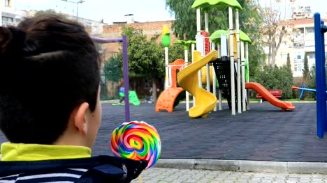 child-eating-lollipop-at-the-playground