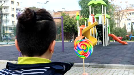 Child-eating-lollipop-at-the-playground