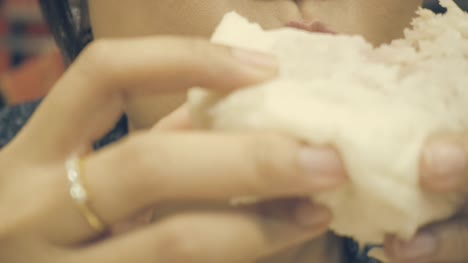 close-up-shot-:-Asian-woman-eating-a-steam-bun