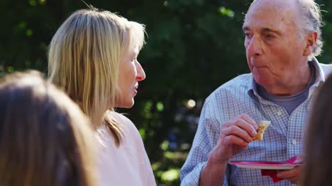 Middle-aged-woman-and-senior-man-talking-at-a-block-party