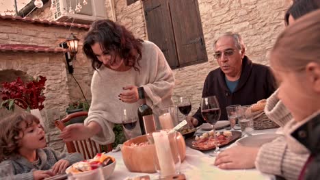 Abuela-que-sirve-comida-casera-para-familia-en-pueblo-Mediterráneo