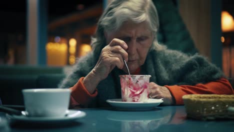 Schöne-alte-Frau-isst-Dessert-in-einem-café