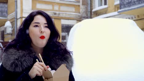 Junge-koreanische-isst-eine-Nudeln-auf-der-Straße-bei-Schneefall