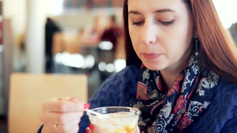 mujer-comiendo-helado-en-una-cafetería