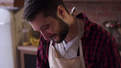man-in-apron-cooking-at-the-kitchen