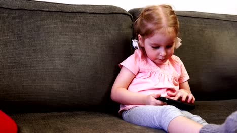 Kleines-Mädchen,-die-Spaß-mit-ihrem-Smartphone-während-sie-gefüttert-wird