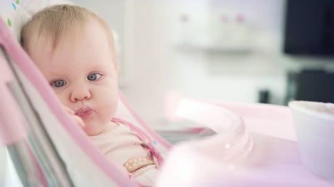 Baby-eating-with-spoon.-Cute-kid-taste-porridge.-Toddler-eating-in-baby-chair