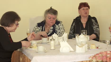 Mujer-Senior-con-amigas,-comer-pastel-en-la-mesa