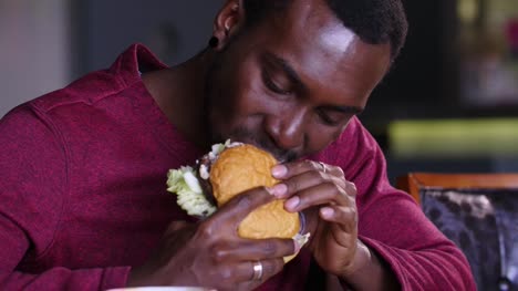 glücklich-afroamerikanische-dicker-Mann-einen-Hamburger-Essen.