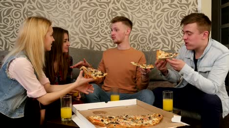 Young-people-in-casual-clothes-eating-pizza,-talking,-laughing