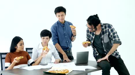 Asiaten-essen-Pizza-während-der-Arbeit-im-Büro-zusammen.-Menschen-Arbeitskonzept.