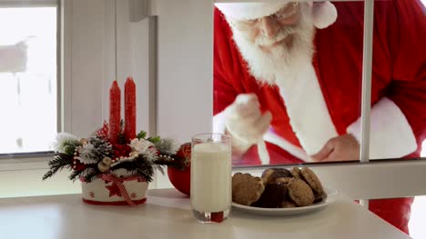 Santa-Claus-quiere-probar-leche-y-galletas-y-mirar-a-través-de-un-vidrio
