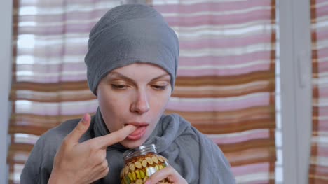 Muslim-woman-in-a-headscarf-dips-her-finger-in-honey-with-nuts-in-the-jar.-Eats-honey-from-finger.