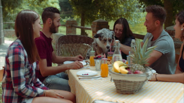 Grupo-de-amigos-haciendo-el-desayuno-al-aire-libre-en-un-paisaje-tradicional.-filmada-en-cámara-lenta
