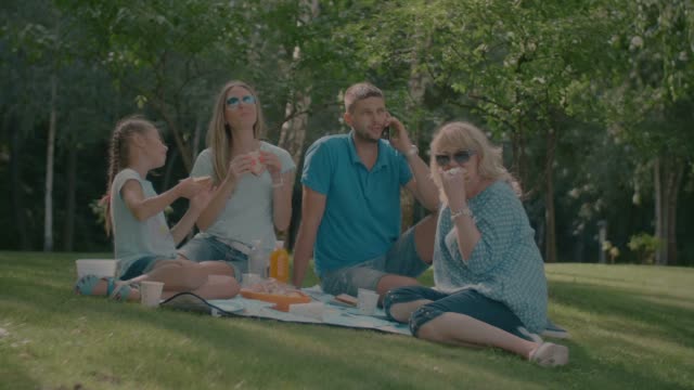 Positive-multi-generation-family-enjoying-picnic